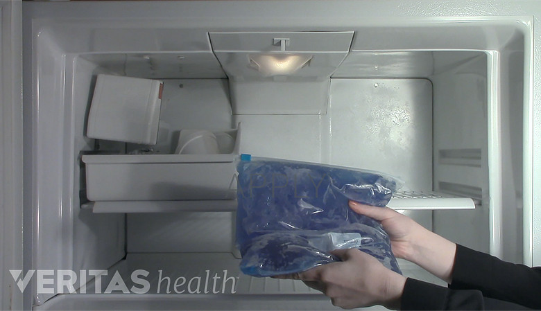 Woman grabbing ice pack out of freezer